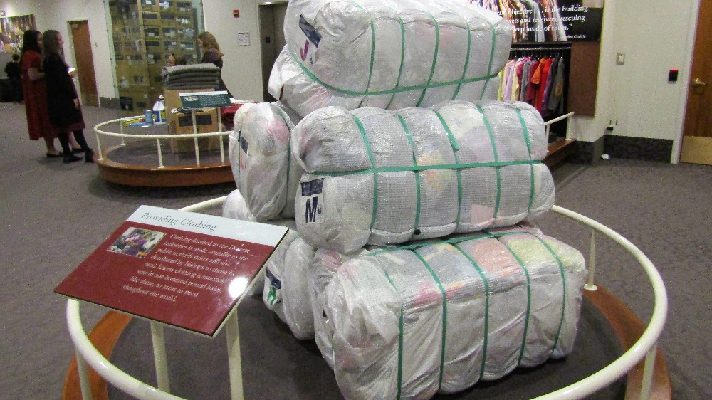 Fardos de ropa excedente utilizados por Deseret Industries en una instalación interior de clasificación y gestión textil.